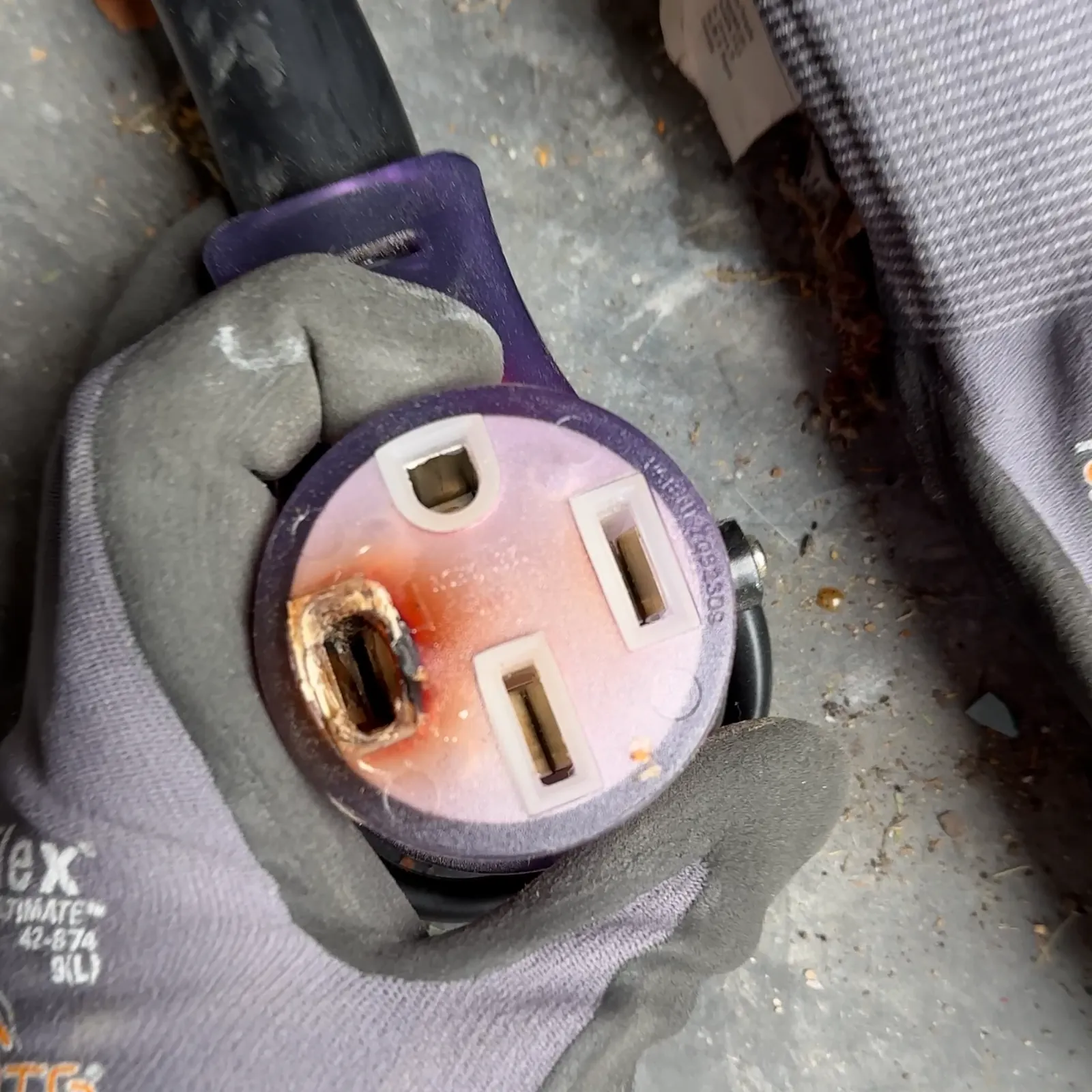 Burned slot on the receptacle end of an extension cord used with an EV charger