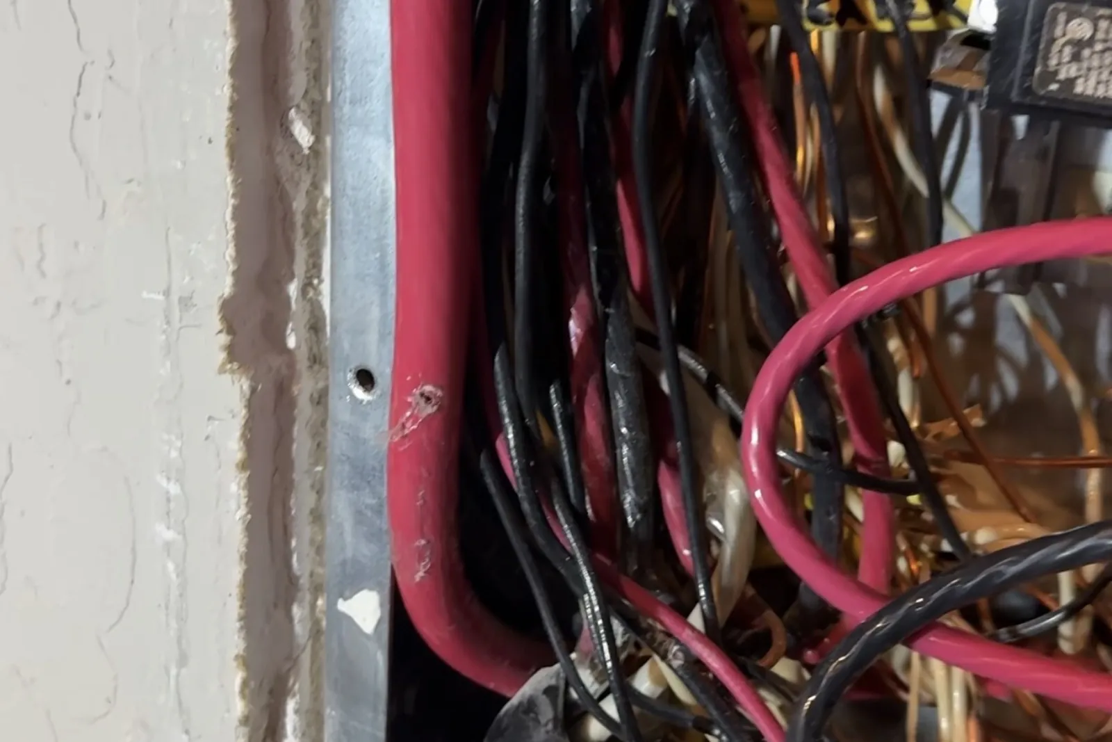 200-amp service conductor pressed against the side of an electrical panel in a San Jose home, with damaged insulation