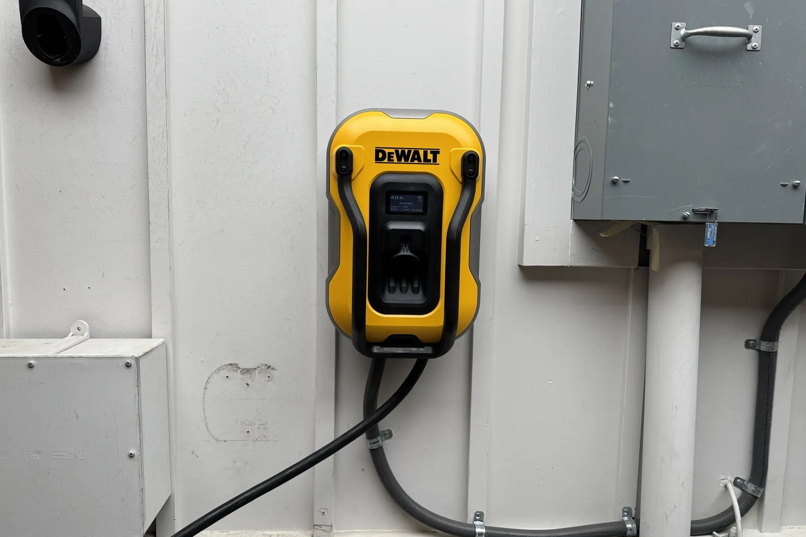 DeWalt Level 2 EV charger hardwired on an exterior wall next to an electrical panel in Los Altos