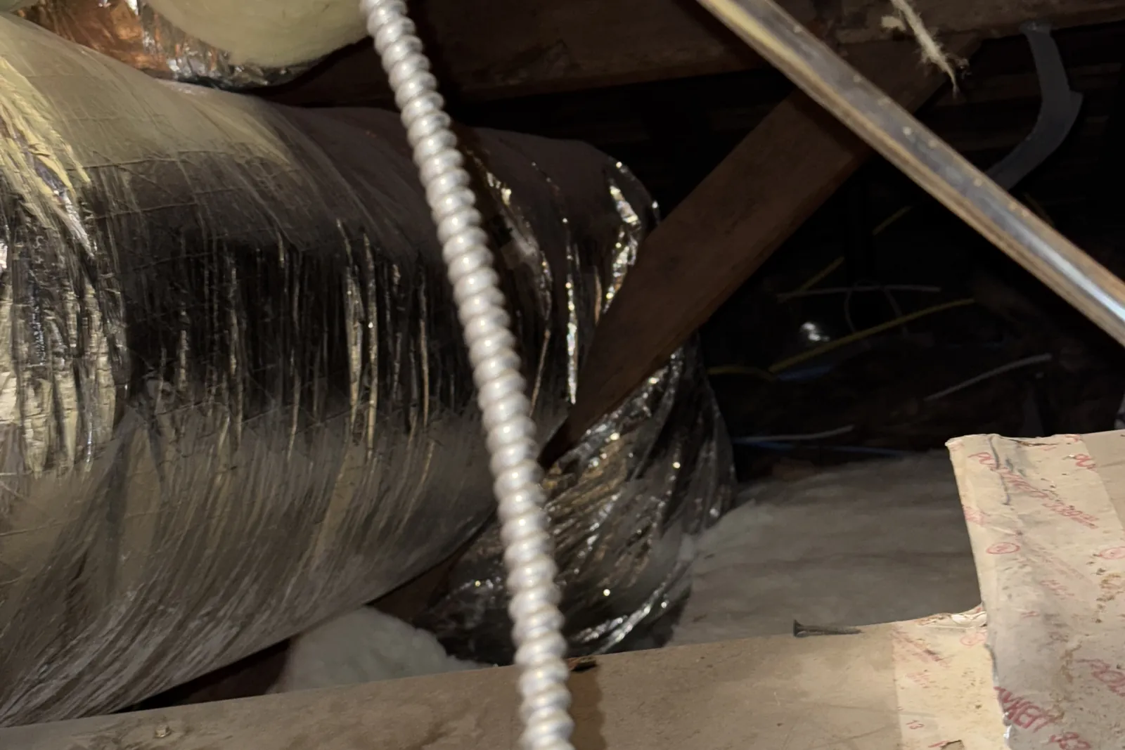 Furnace return duct running under attic framing and insulation in a San Jose home