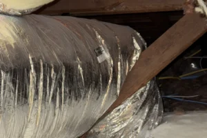 Flexible return air duct for a new furnace resting on an attic cross brace in a San Jose home
