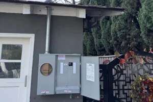 New meter main panel and service conduit installed on the outside wall of a home for an overhead service upgrade