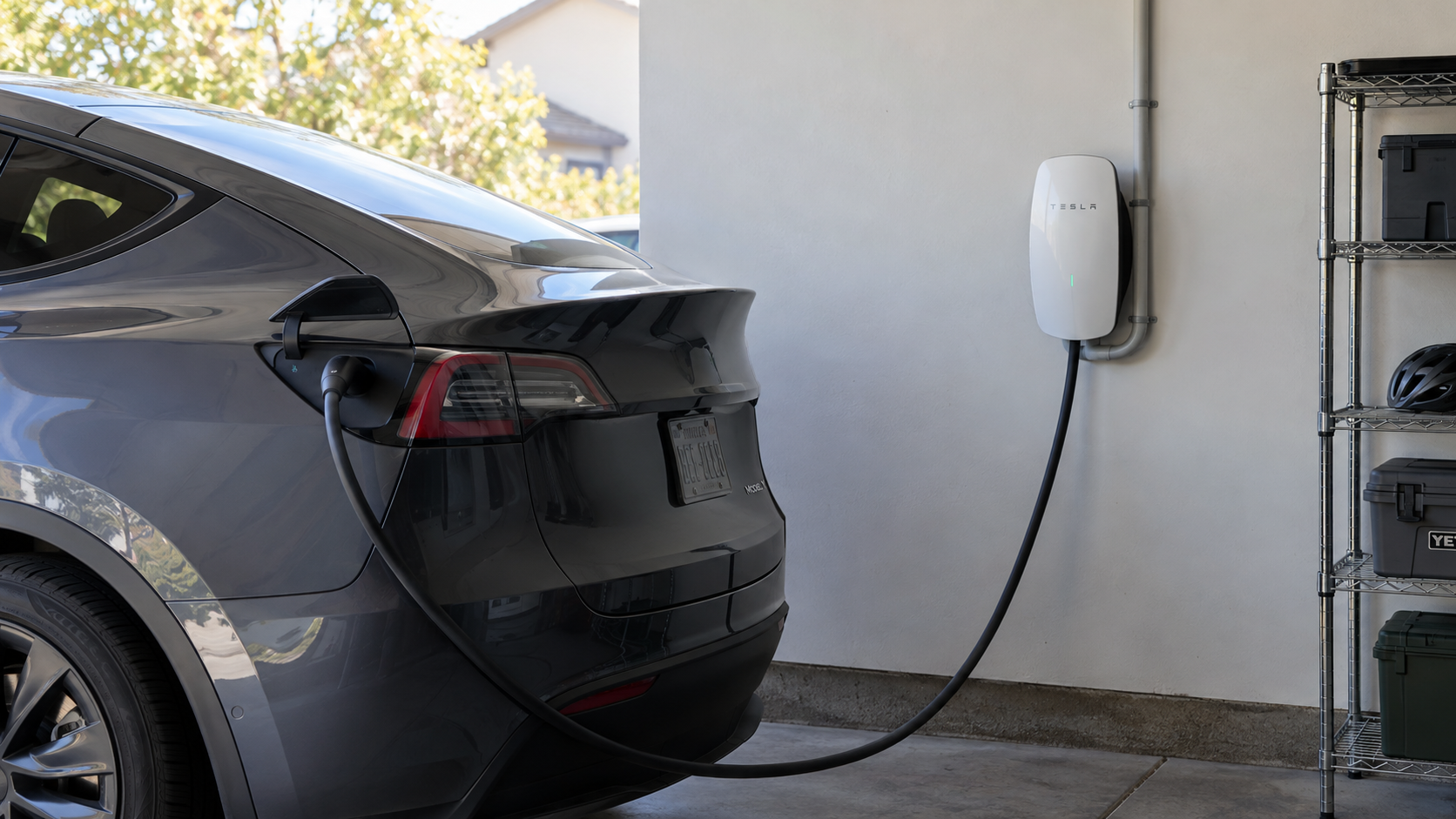 Concept image of a Tesla Wall Connector connected to a parked Tesla in a garage