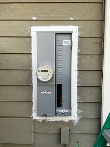 Exterior electrical meter and breaker enclosure mounted on horizontal house siding