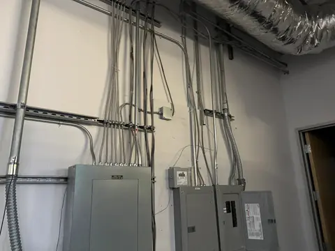 Interior electrical panels connected to surface-mounted metal conduit